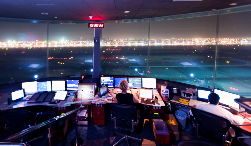 Air Traffic Controller at Dubai Airport Tower by night.